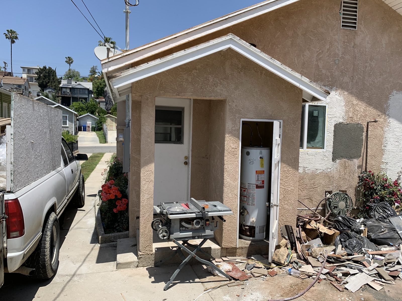 LA side-yard job with debris and a water heater before cleanout